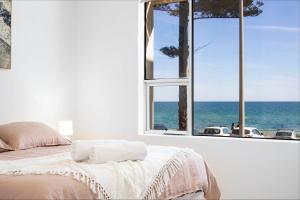 Henley Beach SouthにあるLuxury Beachfront Retreat on Henley Beach Esplanadeの海の見えるベッドのある寝室