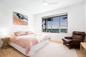 Henley Beach SouthにあるLuxury Beachfront Retreat on Henley Beach Esplanadeのベッドと椅子と窓のある寝室 +13枚の写真
