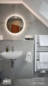ein Bad mit einem Waschbecken und einem Spiegel in der Unterkunft Hotel-Restaurant Schmachtenbergshof in Essen