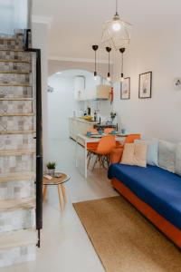 a living room with a blue couch and a kitchen at Home Santa Clara in Albufeira