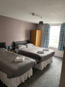 1 dormitorio con 2 camas y ventana en Hampton Hotel & restaurant en Llandrindod Wells