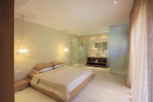 1 dormitorio con 1 cama y baño con lavamanos en Solis Lindos Villa, en Lindos