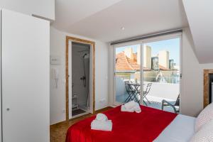 - une chambre avec un lit rouge et une grande fenêtre dans l'établissement Memories of Lisbon, à Lisbonne