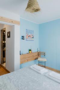 1 dormitorio con cama blanca y pared azul en Home Santa Clara en Albufeira