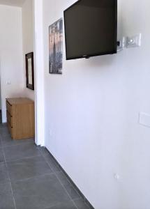 uma televisão de ecrã plano pendurada numa parede branca em La Ca' Pezzana Affittaly Apartments em Bolonha