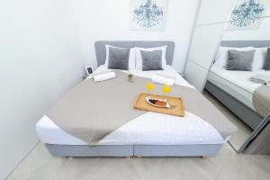 a bedroom with a large bed with a tray on it at Holiday Home Maria one minute from -Beach in Zadar