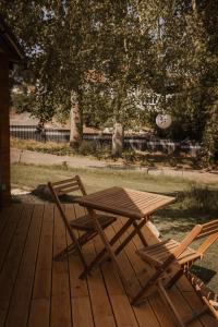 een houten picknicktafel en twee stoelen op een terras bij Tinyhaus & Souterrain Apartment in Ortenberg in Ortenberg