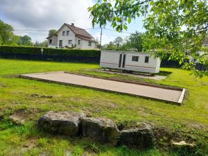 un remolque en medio de un campo con una casa en chambre comtoise 