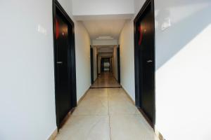 um corredor com portas pretas e piso em azulejo em Townhouse Halcyon Hi-Tech City Near Medicover Hospital em Kondapur
