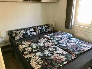 a bed with a floral comforter in a bedroom at Mobilheim im Amazonas Camp - viel Platz und Komfort in Loitz