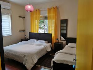 a bedroom with two beds and a window with yellow curtains at Ramallah Hostel in Ramallah