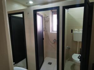 uma casa de banho com um WC e uma porta de duche em vidro. em Ramallah Hostel em Ramallah