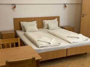 a bed with white sheets and pillows on it at Esprit Hotel in Budapest