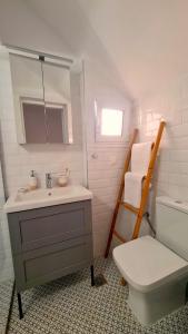 een badkamer met een wastafel, een toilet en een spiegel bij Yannis Guest House in Aegina Town