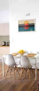 une salle à manger blanche avec une table et des chaises dans l'établissement Yannis Guest House, à Égine