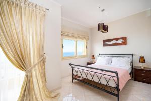a bedroom with a bed and a window at Artemisia Sunset View in Sitia