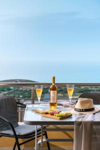 a table with a bottle of wine and two glasses at Artemisia Sunset View in Sitia