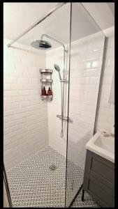 une douche avec une porte en verre à côté d'un lavabo dans l'établissement Yannis Guest House, à Égine