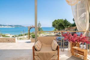 een kamer met een stoel en uitzicht op de oceaan bij Orientem Villa in Argassi
