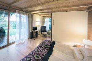 a bedroom with a bed and a living room at Parkhotel Holzner in Soprabolzano