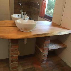 a bathroom with a wooden counter with two sinks on it at Domek Basia in Deskurów +27 photos