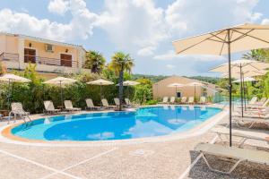 een zwembad met stoelen en parasols in een resort bij ILENA HOTEL in Acharavi
