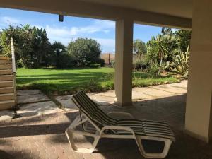 a green and white chair sitting on a patio at Scrusciu do Mari in Butera