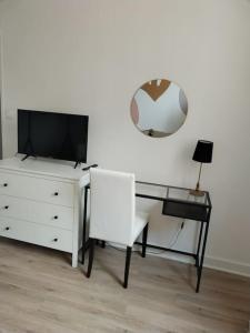 a desk with a television and a chair and a mirror at Massilia Calling love Appartement de standing 8 personnes Marseille proche métro parking facile in Marseille