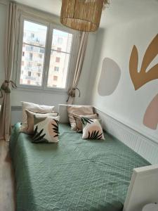 um quarto com uma cama verde com almofadas em Massilia Calling love Appartement de standing 8 personnes Marseille proche métro parking facile em Marselha
