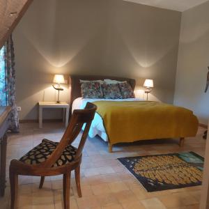 a bedroom with a bed with a chair and two lamps at Maison d'hôtes de La Roche Tabary 