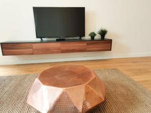 a living room with a flat screen tv and a table at Wonderful Apartment near City Mall in Podgorica