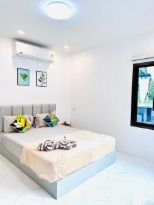 - une chambre blanche avec un grand lit et des serviettes dans l'établissement Avita Pool Villa, à Sichon