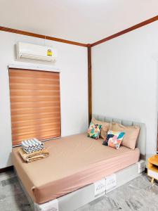 een klein bed in een kleine kamer met een deur bij Avita Pool Villa in Sichon