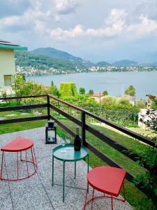 twee stoelen en een tafel op een balkon met een meer bij Villa Panoramica in Lavena Ponte Tresa