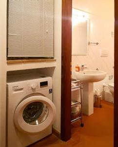 y baño con lavadora y lavamanos. en Chianti For Two, en Montagnana Val di Pesa