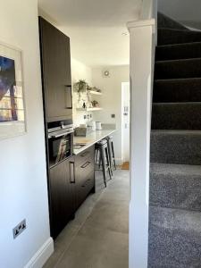 a kitchen with a staircase and a kitchen with a counter at LymingtonBnB in Lymington
