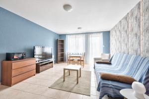 ein Wohnzimmer mit einem Sofa und einem TV in der Unterkunft Dom & House - Apartment Smart Studio Sopot in Sopot