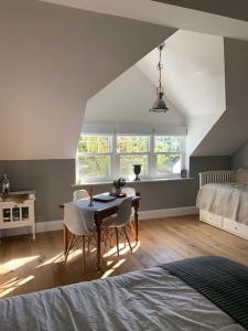 ein Schlafzimmer mit einem Tisch, Stühlen und einem Bett in der Unterkunft LymingtonBnB in Lymington