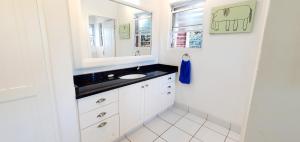 a bathroom with a sink and a mirror at Beach Haven - Sleeps 10 - Tastefully Furnished Holiday Home! in Margate +25 photos