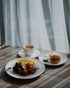 una mesa con dos platos de comida y una taza de café en Gogo Hotel en Taichung