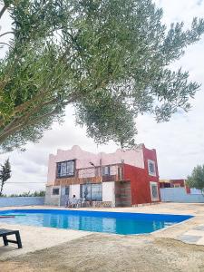 una casa con piscina frente a un edificio en "Plaisir en Pleine Nature Villa Ferme avec Piscine Privée pour un Séjour Relaxant en Nzala