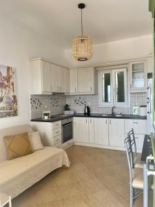 a kitchen with white cabinets and a couch in a room at Gregos house in Antiparos +18 photos