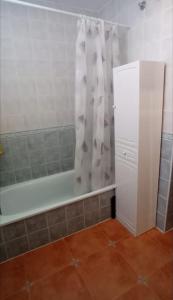 y baño con bañera y cortina de ducha. en Casa La Puerta de Ronda en Cuevas del Becerro