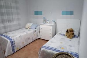 um quarto para crianças com 2 camas e um ursinho de peluche em Casa La Puerta de Ronda em Cuevas del Becerro