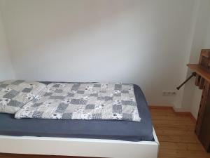 a bed with a blue and white quilt on it at Ferienwohnung Am Grünen Zipfel in Dresden