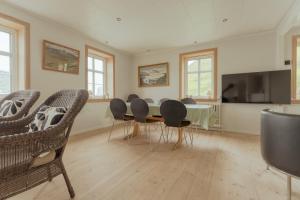 a dining room with a table and chairs and a television at Breathtaking View / 5-BR House / Scenic Village in Bøur
