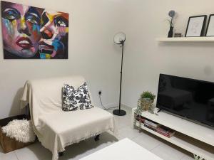 a living room with a chair and a television at STS 21, Nicosia-Lakatamia one-bedroom Apartment in Kato Lakatamia