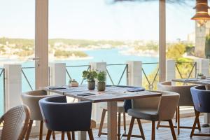 a table and chairs with a view of the water at Catalonia Mirador des Port in Mahón