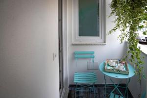 a small table and two chairs next to a wall at La casa del pescatore in Cala Gonone