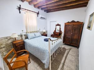 a bedroom with a bed and a chair at Athena's Pool Oasis in Skarinou